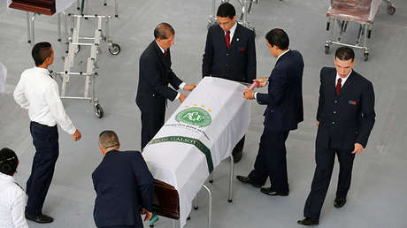 Personal funerario prepara un ataúd con los restos de una víctima del vuelo siniestrado del club Chapecoense.