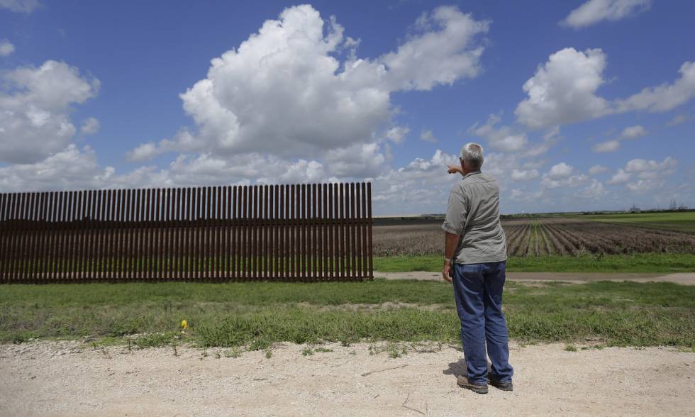 Un hombre señala un tramo de la valla fronteriza en Brownsville (Texas) en una imagen de 2005