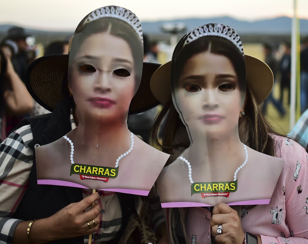 Dos mujeres usando máscaras con el rostro de la cumpleañera (AFP)