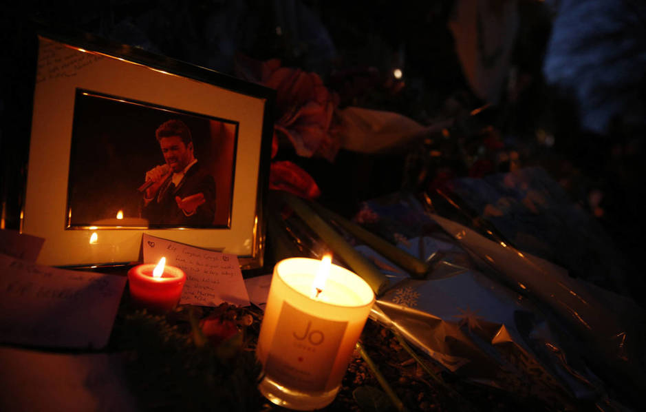 Los fans dejaron flores, velas y otros recordatorios en la puerta de la casa de George Michael. (Reuters/Neil Hall)