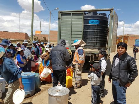 Vecinos del Distrito 7 de El Alto reciben agua de un camión que lleva un tanque de agua.