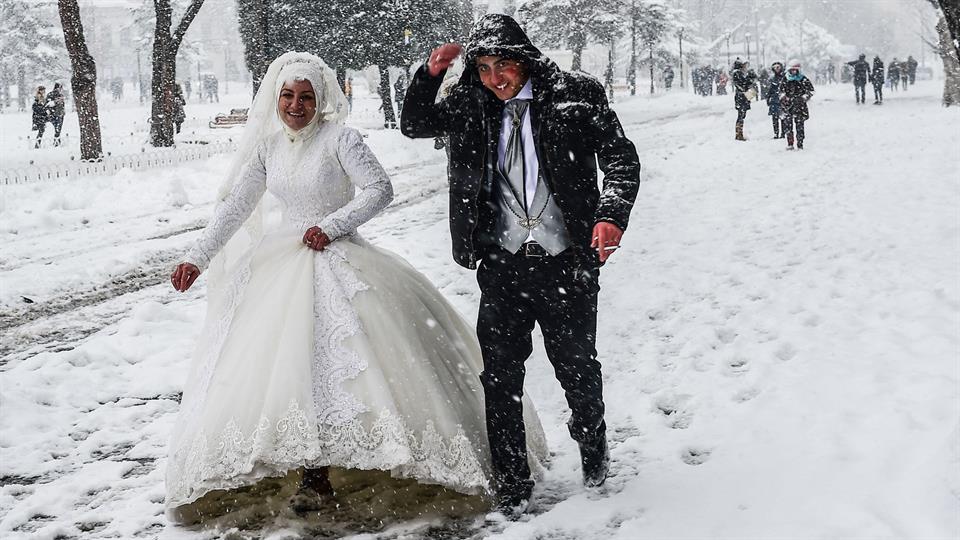 Ni la nieve, ni las extremas bajas temperaturas lograron que ésta pareja de recién casados caminara por la plaza de Sultanahmet, en Estambul. Foto: AFP / Yasin Akgul