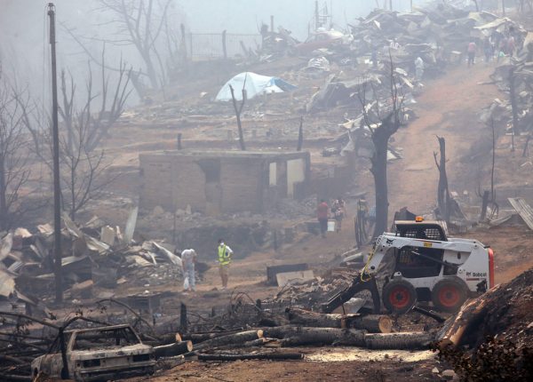 Pobladores comienzan los trabajos de retiro de escombros, el sábado, luego de un incendio forestal en la localidad de Santa Olga, en la región del Maule, al sur de Santiago (Chile).
