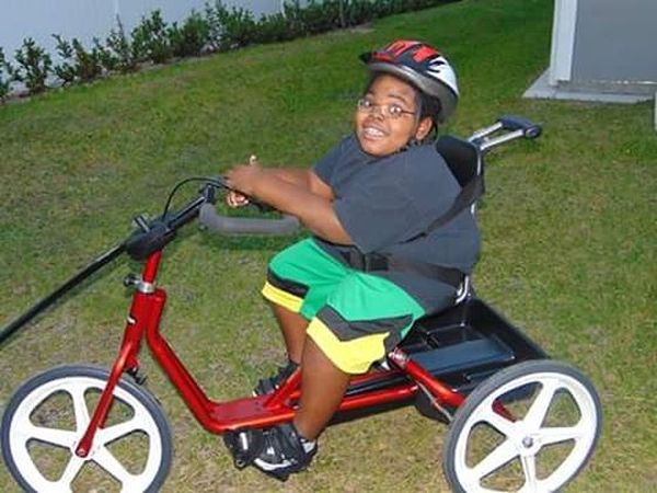 Michael Whitaker-Russell en una bicicleta para niños con problemas motores