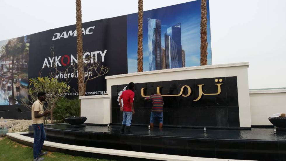 Varios operarios colocan las letras en árabe del apellido Trump a la entrada del nuevo club de golf en Dubái de su organización.