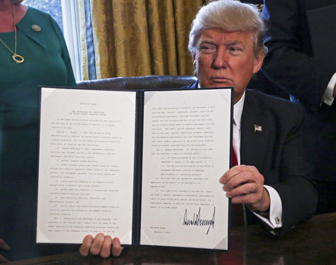 Donald J. Trump, enseña una orden ejecutiva firmada en el Despacho Oval de la Casa Blanca este 3 de febrero. Foto: EFE