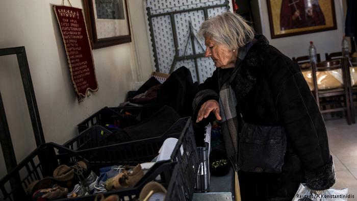 Pobreza en Grecia: una mujer busca vestimenta de donaciones.