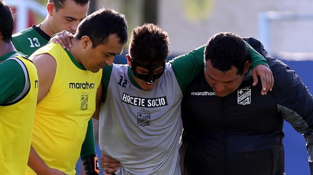 Caleb Cardozo (centro) sale apoyado del médico Javier Gómez (dcha.) tras lesionarse la rodilla. Foto: Fuad Landívar %image_alt%