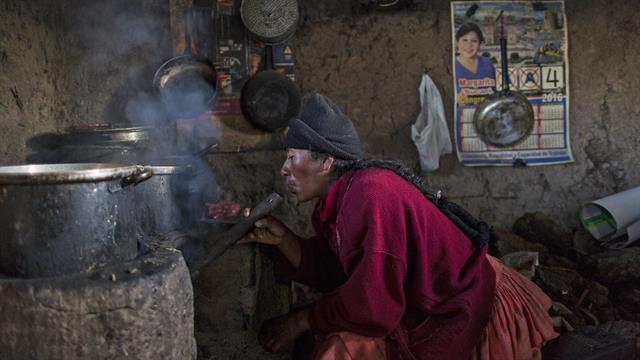 Lilian Ávila Díaz enciende su estufa de leña para preparar el almuerzo para su familia en Coata, un pequeño pueblo a orillas del lago Titicaca, en la región de Puno, Perú