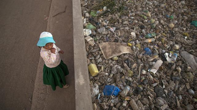 María José Campos Inquilla de pie junto al río Torococha lleno de basura cerca de una planta de tratamiento de residuos municipales que se alimenta en el Lago Titicaca, en Juliaca, en la región de Puno, Perú