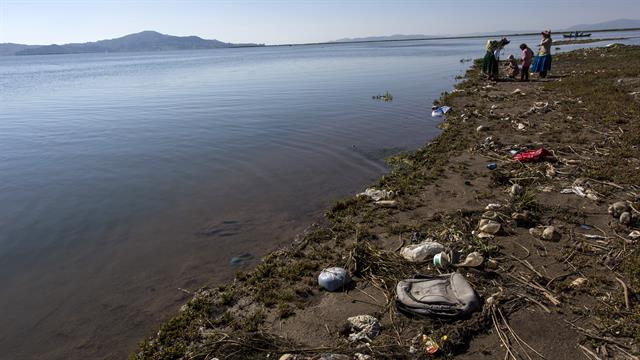 La basura cubre la costa del lago Titicaca, donde la activista ambiental Maruja Inquilla habla con los habitantes de Coata, en la región de Puno, Perú