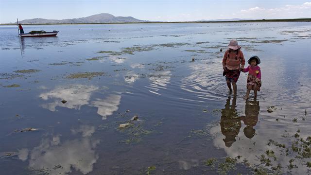 Primos de la familia Avila buscan juguetes desechados en las orillas del Lago Titicaca, en Coata, en la región de Puno, Perú.