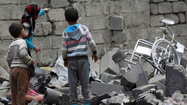 Niños observan los restos de un bombardeo en Saná, capital de Yemen (AFP)