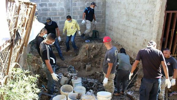 Personal forense trabaja en la remoción de los restos humanos (AFP)
