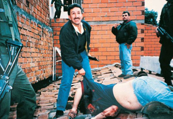 El comandante Aguilar Naranjo sonríe junto al cuerpo de Escobar. El zar de la droga fue acribillado por el Bloque de Búsqueda mientras huía por un tejado en Medellín. Fue el 2 de diciembre de 1993
