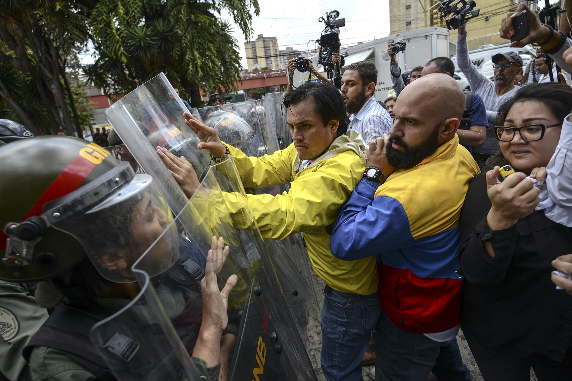 Los diputados venezolanos opositores Carlos Paparoni (Centro) y Carlos Bozo (Derecha) forcejean con la Guardia Nacional en protesta frente a la Corte Suprema de Justicia (AFP)