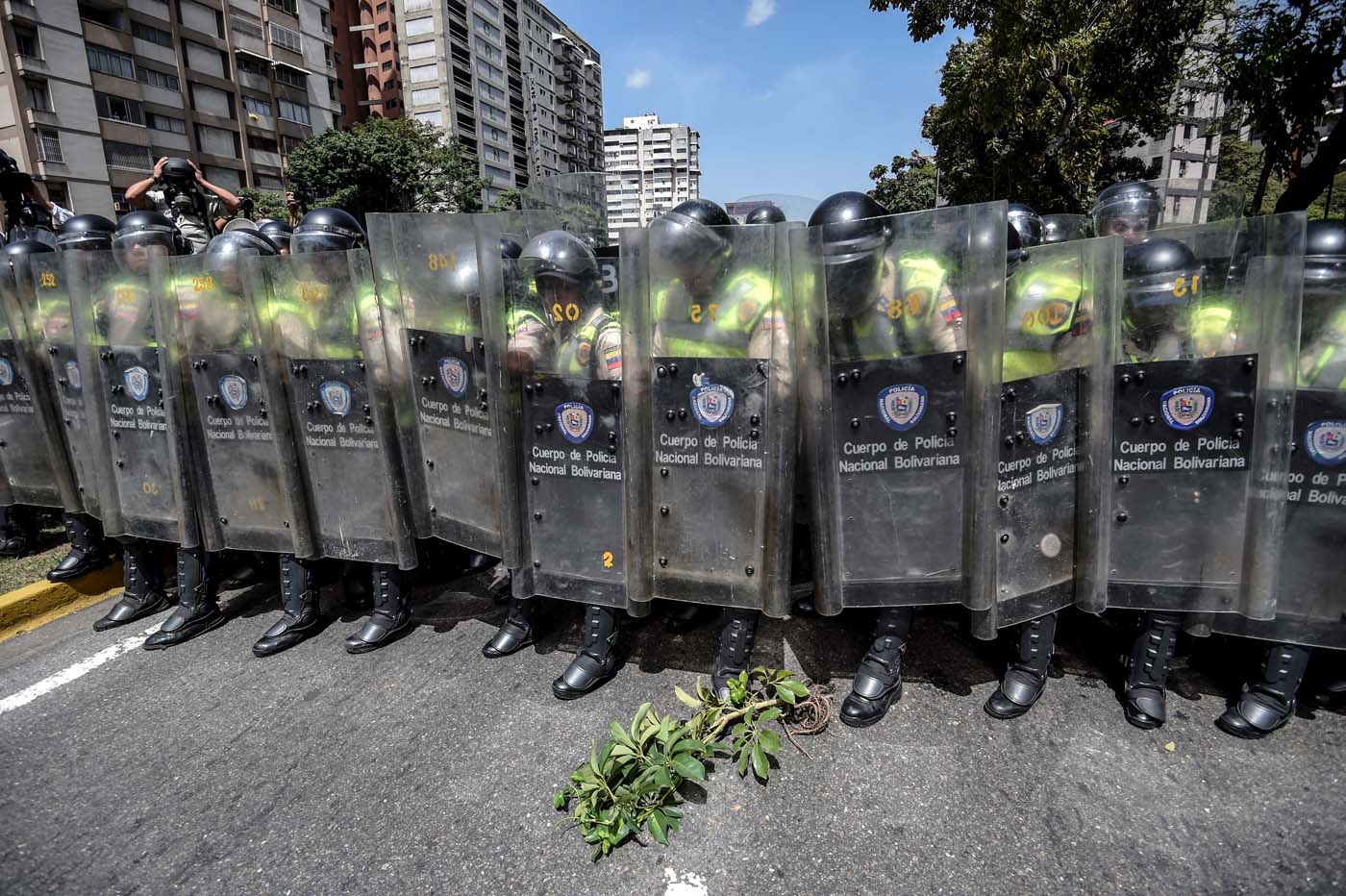 Riot police officers block an avenue during a protest against Nicolas Maduro