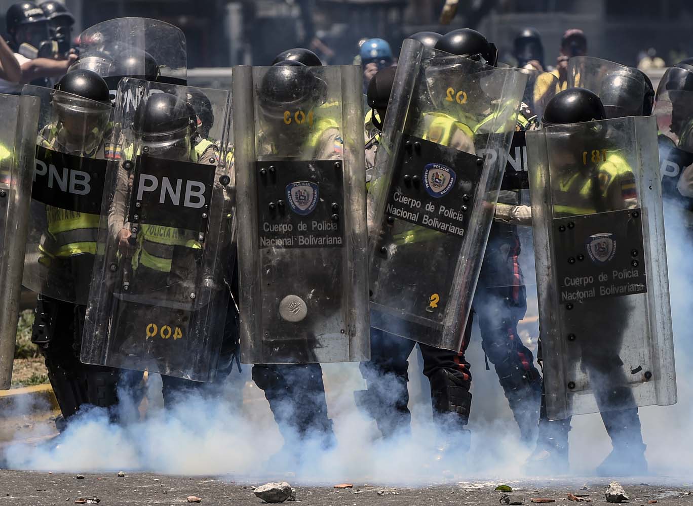 Bolivarian police agents hold their shields and prepare for confrontation during a protest against Nicolas Maduro
