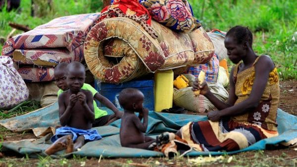 Una mujer sudanesa obligada a desplazarse con su familia hacia Uganda por los enfrentamientos en su país (Reuters)