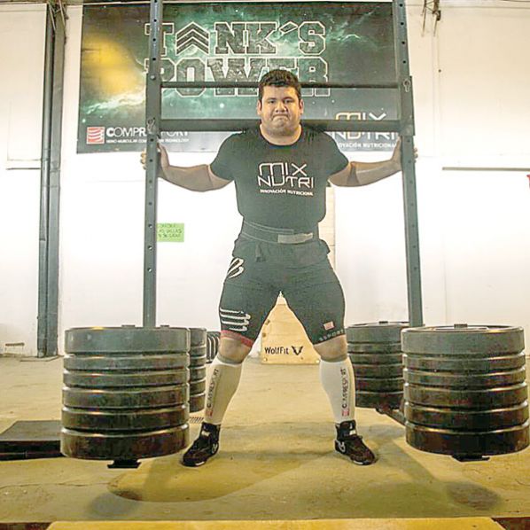 CRISTIAN QUIROGA SE EJERCITA EN SU GIMNASIO TANK’S POWER GYM. EL BANNER DE SU NEGOCIO ESTÁ DETRÁS DEL ATLETA.