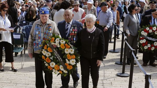 Veteranos de la Segunda Guerra Mundial dejan una corona de flores en la ceremonia de inicio del Día del Recuerdo del Holocausto (AFP)