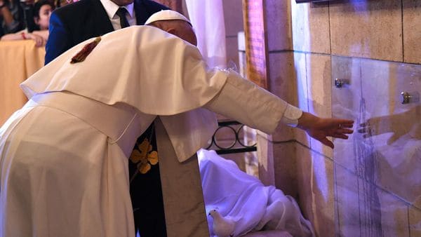 El papa Francisco observa las marcas de sangre que quedaron en las paredes de la iglesia (AFP)