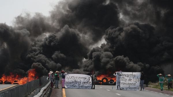 Las protestas en la carretera a Puebla, el jueves pasado, luego de que la policía disparara contra mujeres y niños cuando perseguían a huachicoleros (AFP)