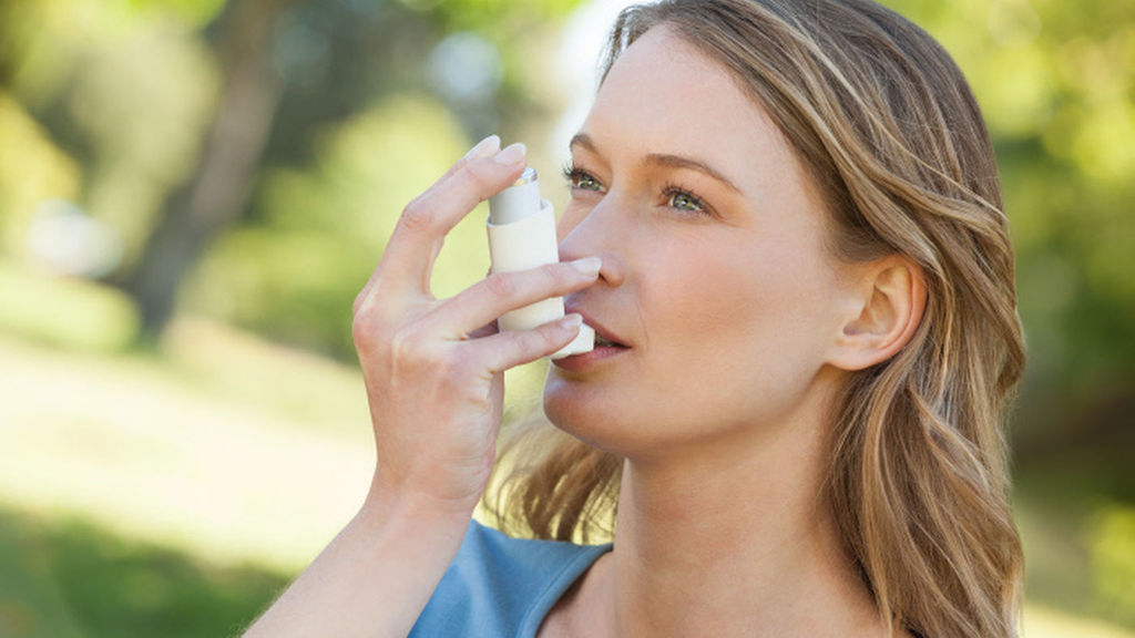Una mujer con un inhalador para el asma