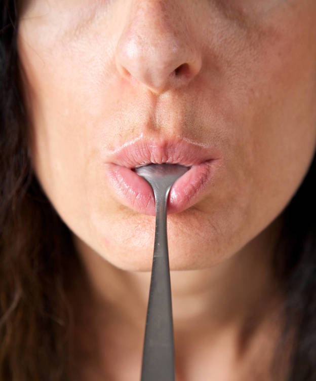 Foto: Una mujer chupa una cuchara. (iStock)