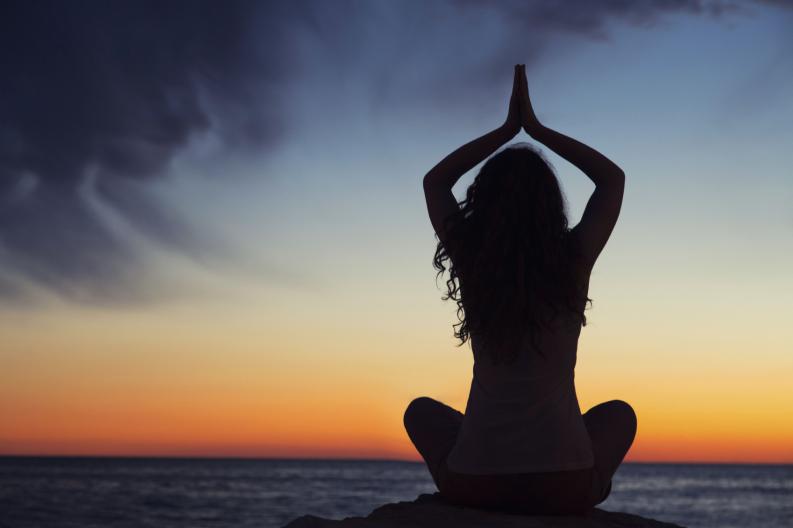Joven meditando oceano 
