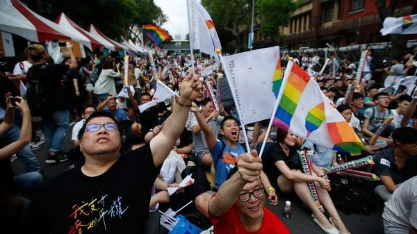 Integrantes de la comunidad LGBT  se abrazan mientras celebran la decisión del Tribunal Constitucional sobre el matrimonio entre personas del mismo sexo ante el Parlamento en Taipéi (EFE)