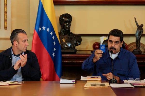 El presidente venezolano Nicolas Maduro muestra una copia de la constitución este jueves en el Palacio de Miraflores. A su derecha, el vice presidente Tareck El Aissami (Reuters)