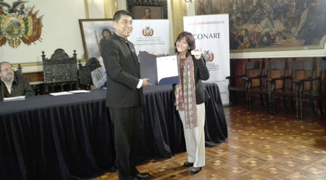 Canciller Huanacuni entrega el certificado de nacionalización a una ciudadana refugiada en Bolivia