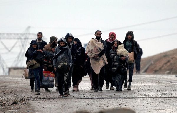 Iraquíes desplazados caminan bajo la lluvia (Reuters)