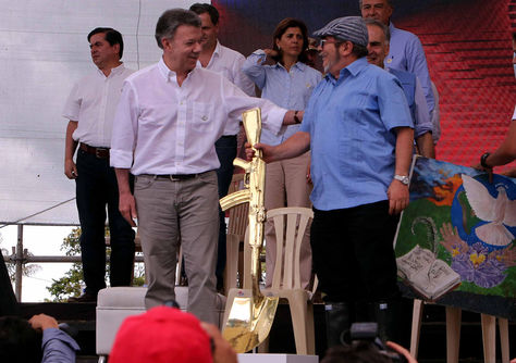 El presidente de Colombia, Juan Manuel Santos (izq.), conversa con el máximo líder de las FARC, Rodrigo Londoño, alias Timochenko, durante la ceremonia de dejación de armas. Foto: EFE