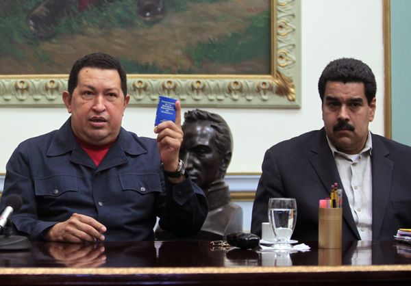 El ex presidente de Venezuela Hugo Chávez junto a Nicolás Maduro el 8 de ciciembre del 2012, con una copia de la Constitución Bolivariana (AP)