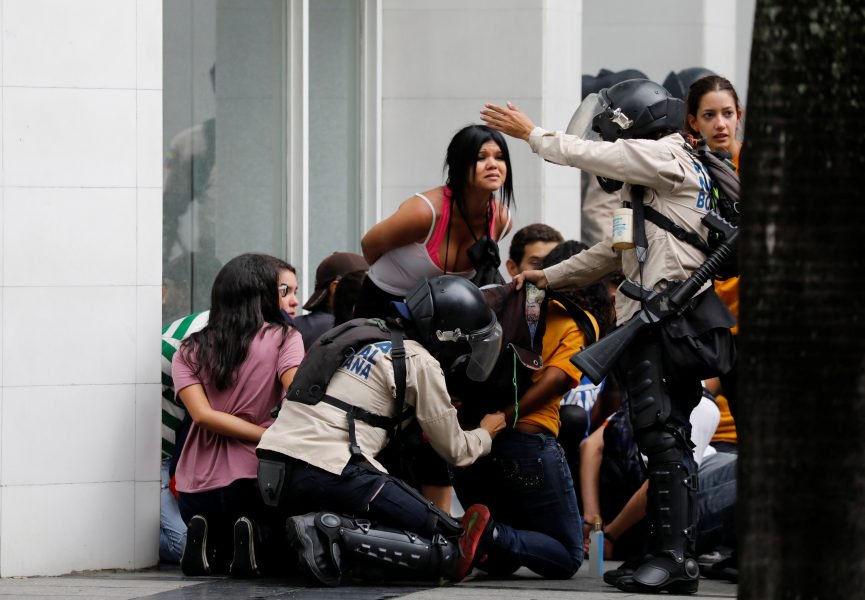 Police detain protesters during a rally against Venezuela