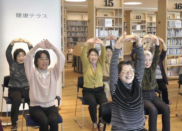 Un grupo de mujeres participan en una sesión de fitness rodeadas de estanterías con libros sobre salud y estilo de vida saludable en la biblioteca de Yamato, en la Prefectura Kanagawa, en Japón. (The Yomiuri Shimbun)