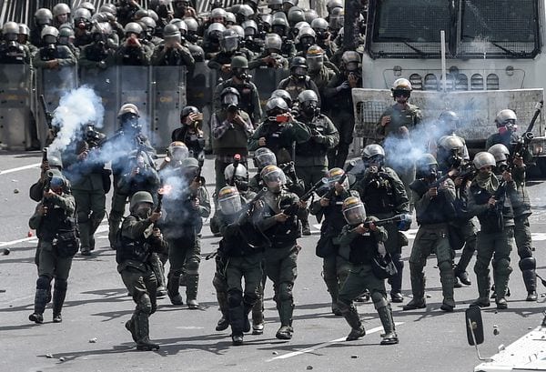 Miembros de la Guardia Nacional Bolivariana reprimen a la oposición en Caracas (AFP)