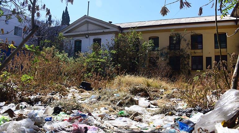 El terreno baldío donde antes funcionaba la morgue está abandonado, con basura y maleza. | Daniel James