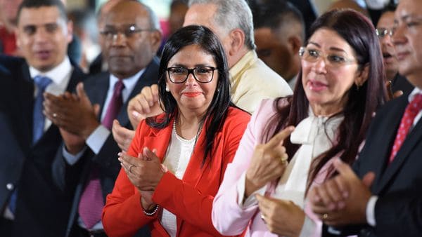Delcy Rodríguez, en el centro de la imagen y al lado de Cilia Flores, la primera dama de Venezuela (AFP)