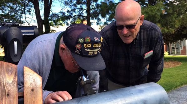 Esta imagen tomada de un video muestra a Gene Brick, de 92 años, y a su hijo, Bartt Brick, mirando a través de un telescopio que fabricaron juntos en 1964, en Madras, Oregon, el 12 de junio de 2017. Padre e hijo tienen previsto seguir juntos el eclipse solar del 21 de agosto de 2017 en Oregon
