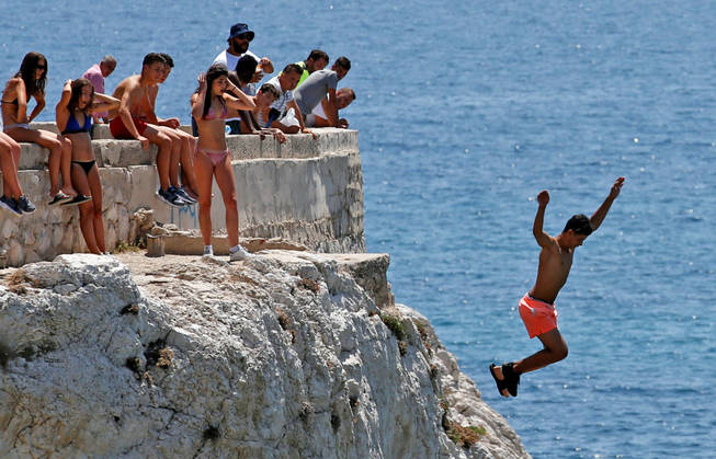 Adolescentes se lanzan al mar en Marsella. (Reuters)
