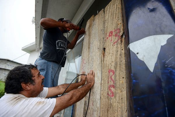 Dos hombres cubren las ventanas de una casa en Veracruz. (REUTERS/Oscar Martinez)
