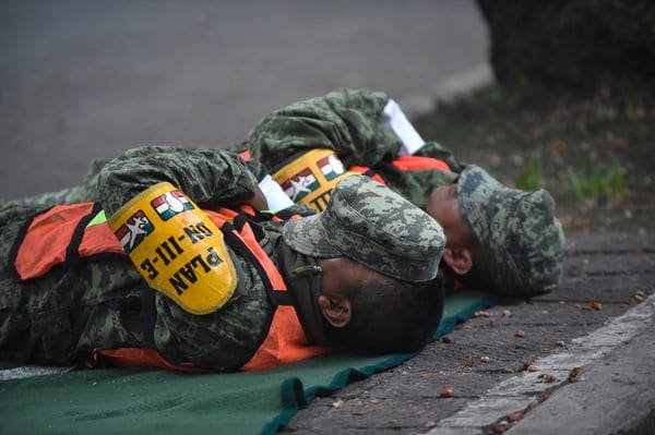 Agotados tras una larga noche, soldados toman un descanso entre los rescates (AFP)