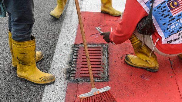 Los empleados trabajando sobre la alcantarilla que produjo el accidente de Romain Grosjean (AFP)