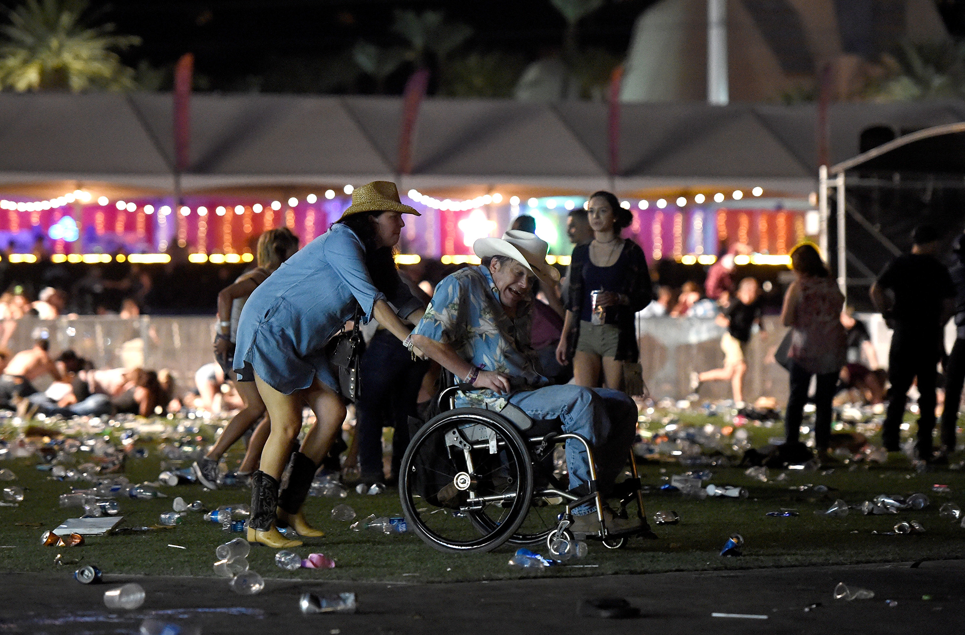 Un hombre en silla de ruedas es ayudado a escapar después de los disparos.