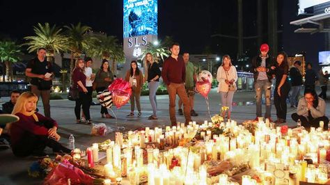 Personas se detienen ante un altar improvisado en memoria a las víctimas del tiroteo ocurrido durante un concierto en Las Vegas. Foto: EFE