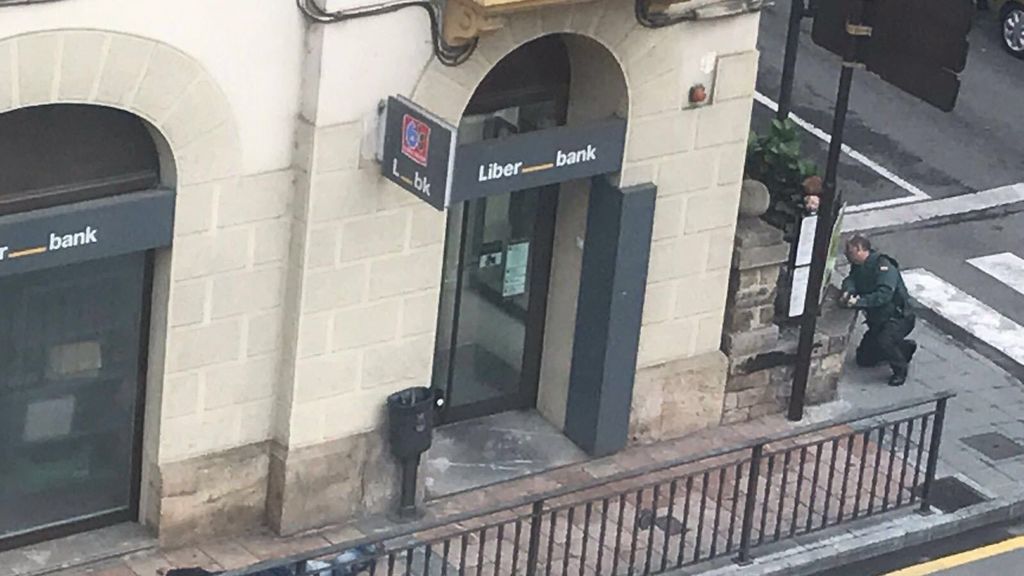 Foto de la sucursal de Liberbank, con el atracador detenido en el suelo.