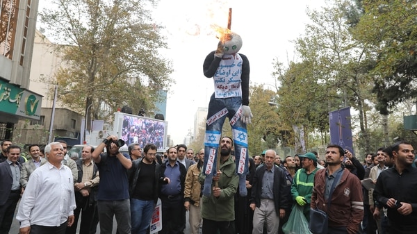 Los manifestantes queman un muñeco con la bandera de Israel (AFP)